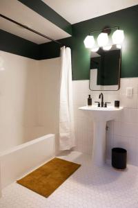 une salle de bain avec un lavabo, une baignoire et un miroir dans l'établissement Charming and Cozy Studio in DT Northfield, à Northfield 6 autres photos