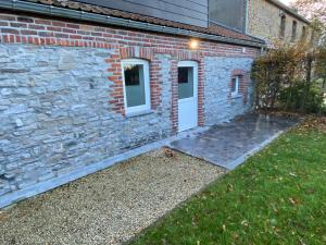 a brick house with a white door and a yard at La Petite Boite in Péruwelz +4 photos