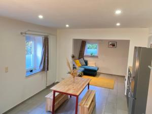 a living room with a table and a couch at La Petite Boite in Péruwelz