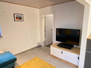 a living room with a flat screen tv on a cabinet at La Petite Boite in Péruwelz