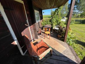 un porche de una casa con un banco y una mesa en Vedru sauna camping, en Väike-Rakke