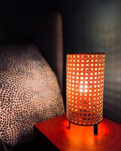 Capdenac-GareにあるLe Republicのベッドの横のテーブルに置かれたオレンジ色のランプ