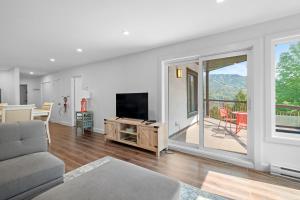 a living room with a couch and a television at Peaceful Condo with Stunning Mountain and Lake Views in Mont-Tremblant