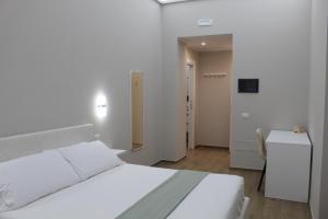 a white bedroom with a white bed and a desk at Lory luxury B&B in Licata