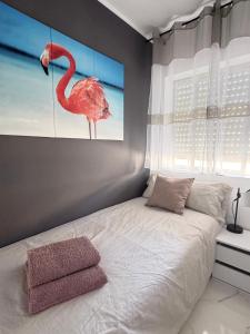 a bedroom with a bed with a picture of a flamingo at Gardenias Friends&Family Beach Appartment in Santiago de la Ribera