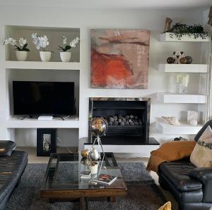 a living room with a couch and a fireplace at Secluded Bays Home in Auckland