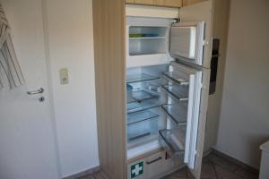 an empty refrigerator with its door open in a kitchen at Foerde-Seasons in Eckernförde