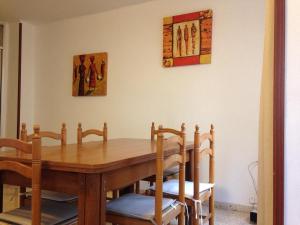 - une table à manger avec des chaises et une table en bois dans l'établissement Apartamentos Calle Mayor, Castellón de la Plana