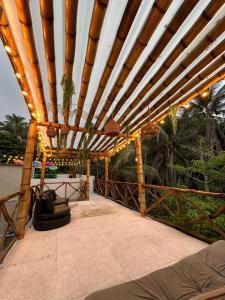 une pergola en bois avec des lumières sur une terrasse dans l'établissement Cabaña salgar - la casa de la playa, à Puerto Salgar 7 autres photos
