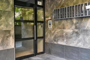 a glass door in front of a stone wall at Central Studio Apartments by Parkside Boutique in Skopje +76 photos