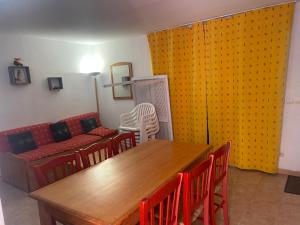 een woonkamer met een tafel, stoelen en een bank bij Chalet lac de la Raviege vue lac in La Salvetat