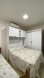 a bedroom with a bed and white cabinets at amplo sobrado perto da praia in Florianópolis
