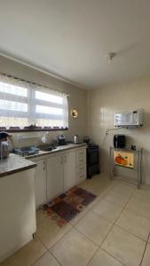 a kitchen with white cabinets and a window and a sink at amplo sobrado perto da praia in Florianópolis