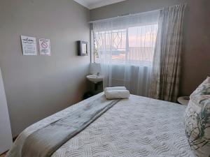 Un dormitorio con una cama grande y una ventana. en Zhantique Guest House 2- Unit 9, en Boksburg 24 fotos más