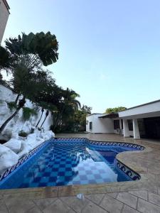 - une piscine bleue dans une cour avec un bâtiment dans l'établissement Casa Campestre en Cali Pance, à Villa Fátima