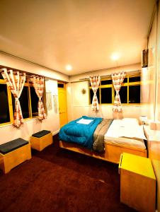 a bedroom with two beds and two windows at Hidden Monkey Stays Darjeeling, Batasia in Darjeeling