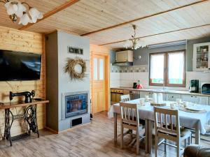a kitchen and dining room with a table and a fireplace at DOMKI U JOANNY in Przezmark