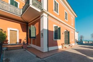 an orange and white building with green shutters at Villa Marina in Marotta