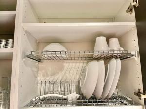 una nevera llena de platos y utensilios blancos en Puma's central flat 2 in Helsinki, en Helsinki