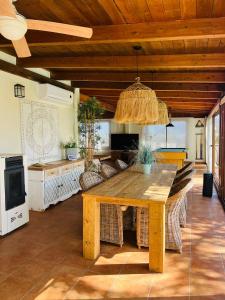 a dining room with a wooden table and a couch at Finca El Paraíso en Agost in Alicante