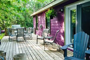 eine Holzterrasse mit einem Tisch und Stühlen darauf in der Unterkunft 2BR Cottage Surrounded by Nature in Tobermory
