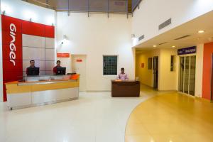 three people sitting at a counter in a hospital lobby at Ginger Mysore in Mysore