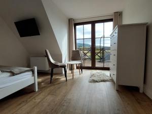 a bedroom with a bed and a desk and a window at Nasza Jodłówka in Jodłów