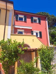 a colorful building with a woman walking in front of it at Casa Vacanze VERDE MARE RELAX in La Spezia