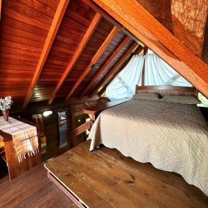 a bedroom with a bed in a room with wooden ceilings at Refúgio Vista Mar Praia da Gamboa - SC in Garopaba