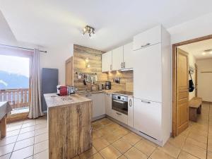 una cucina con elettrodomestici bianchi e una grande finestra di Le Chalet Des Eucherts - Appartement de 6 pièces de 110 m2 pour 10 personne MAE-3194 a Montvalezan