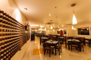 Ginger Indore في إندوري: مطعم فيه طاولات وكراسي في الغرفة