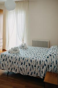 a bedroom with a bed with a blue and white comforter at Casa degli Ulivi - Apartment A in Porto San Giorgio