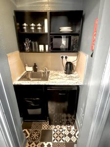 a small kitchen with a sink and a microwave at London Collection - Bayswater in London