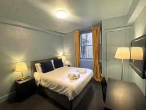 a bedroom with a bed with two towels on it at London Collection - Bayswater in London