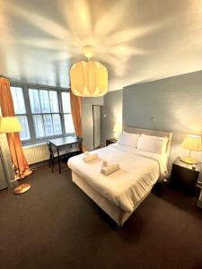 a bedroom with a large bed with two towels on it at London Collection - Bayswater in London