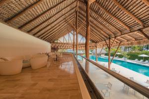 a resort lobby with a swimming pool and a large roof at Apartment nearby the beach at Portillo RAA in Las Terrenas