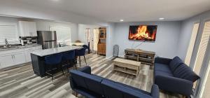a living room with a couch and a fire in the wall at Aria Pocono Home in Tobyhanna