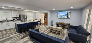a kitchen and a living room with blue couches at Aria Pocono Home in Tobyhanna
