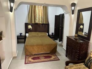 una camera da letto con un letto e un grande specchio di Riad Le Lieu a Tiznit