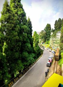 a view of a street with trees and a train on the road at Hidden Monkey Stays Darjeeling, Batasia in Darjeeling