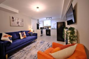 a living room with a blue couch and an orange chair at 1 bedroom, 3 beds, M1, M62, Wi-Fi, Free Parking in Dewsbury