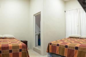 a room with two beds and a window at Apartamentos Petenchel, por Aeropuerto Flores Peten no 3 in Santa Elena