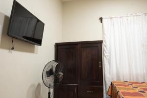 a bedroom with a fan and a flat screen tv at Apartamentos Petenchel, por Aeropuerto Flores Peten no 3 in Santa Elena