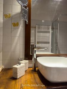 a bathroom with a large white tub and a shower at Poolhouse Oasi del Lupo in Subbiano