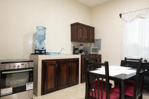 a kitchen with wooden cabinets and a table with chairs at Apartamentos Petenchel, por Aeropuerto Flores Peten no 3 in Santa Elena +14 photos
