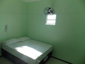 a small room with a bed and a fan at Pousada Cariri in Juazeiro do Norte +11 photos