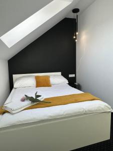 a bedroom with a bed with a black wall at Apartamenty Avia - Energylandia Zator in Spytkowice