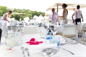 uma mesa com copos de vinho com pessoas ao fundo em Hotel Belvedere em Manerba del Garda