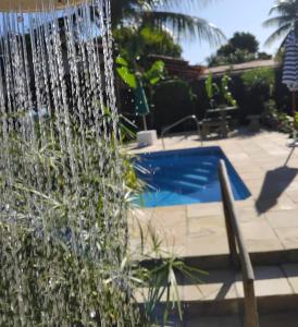 a water fountain in front of a swimming pool at Recanto das Flores Suite Quádruplo in Barra de Santo Antônio