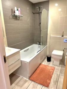 a bathroom with a bath tub and a toilet at Grace Studio in London